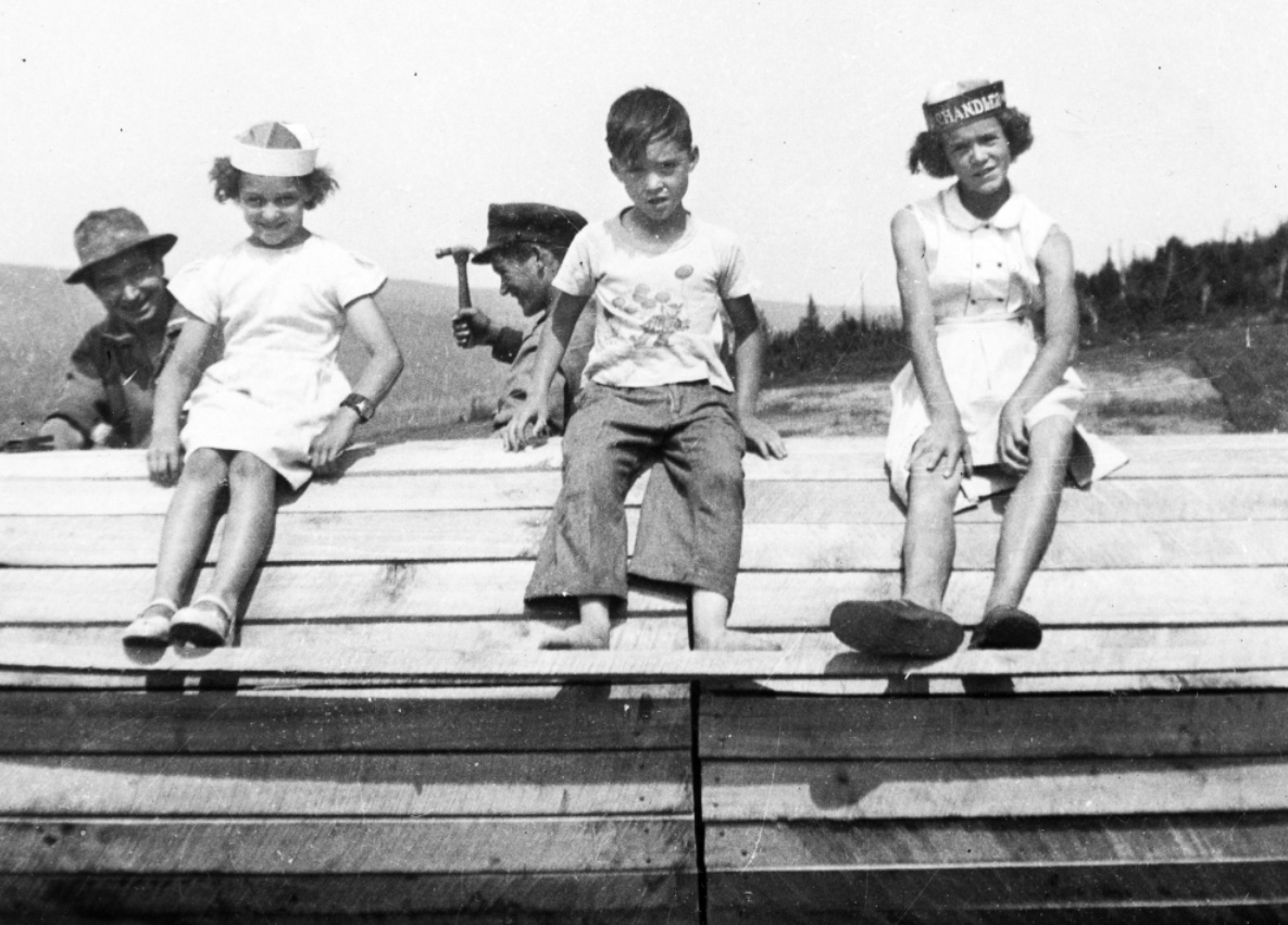 Crédit : Georgette BÉLANGER-RIOUX (Année inconnue, entre 1953 et 1968), « Trois enfants sur un toit avec ouvriers », archive tirée de Résilience 1970 (voir Note 7, p. 25)